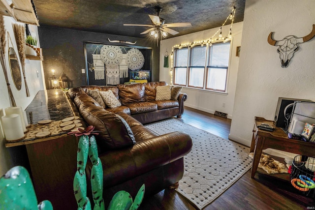 living room with hardwood / wood-style flooring, a textured ceiling, and ceiling fan