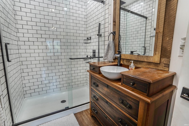 bathroom featuring vanity, a shower with shower door, and wood-type flooring