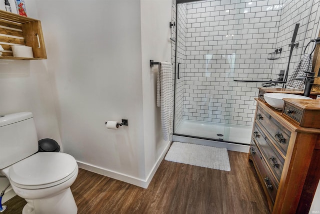 bathroom featuring vanity, hardwood / wood-style floors, a shower with door, and toilet