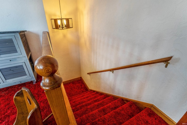 staircase featuring an inviting chandelier