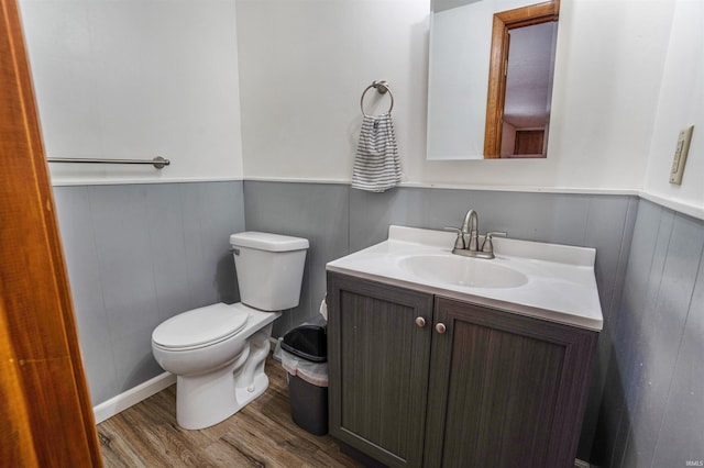 bathroom featuring wood-type flooring, toilet, and vanity