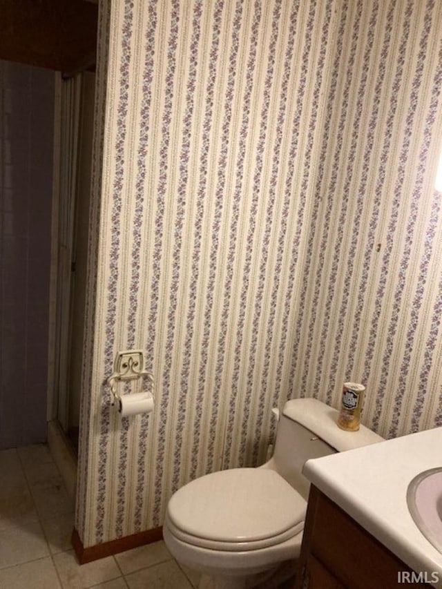 bathroom with tile patterned flooring, vanity, and toilet