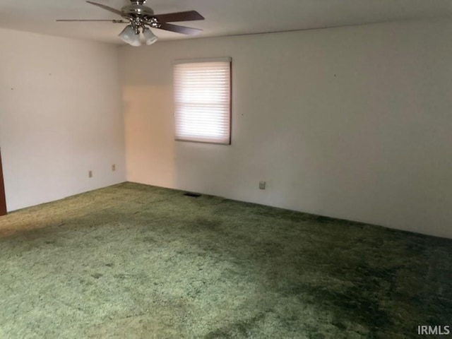 spare room with ceiling fan and carpet