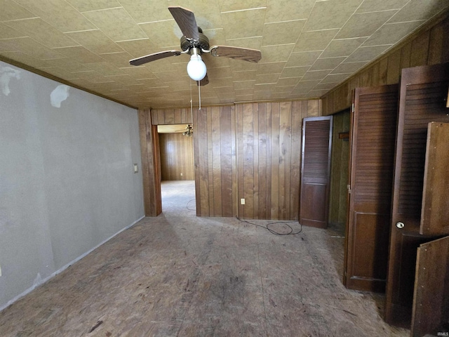 spare room with wooden walls and ceiling fan