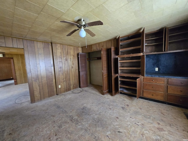 unfurnished bedroom featuring wooden walls and ceiling fan