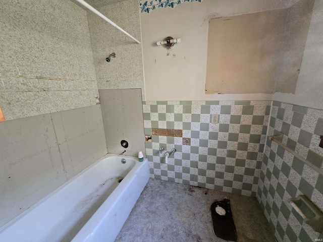 bathroom featuring tile walls and a bath