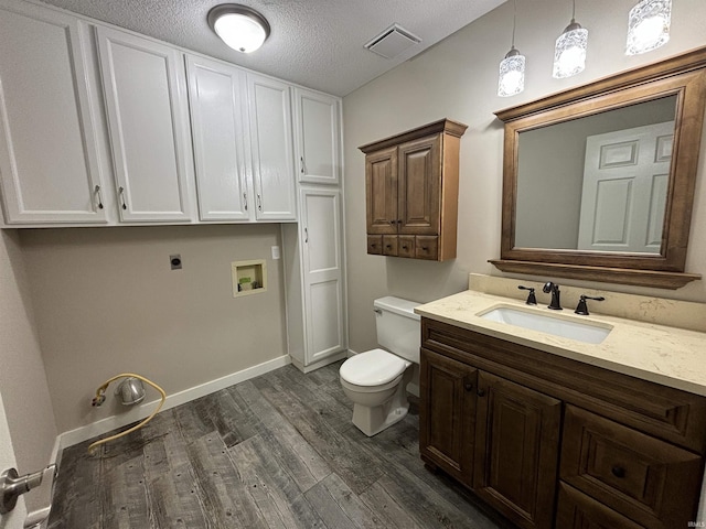 bathroom featuring vanity, hardwood / wood-style floors, a textured ceiling, and toilet