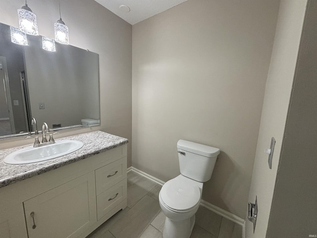 bathroom featuring vanity, tile patterned flooring, and toilet