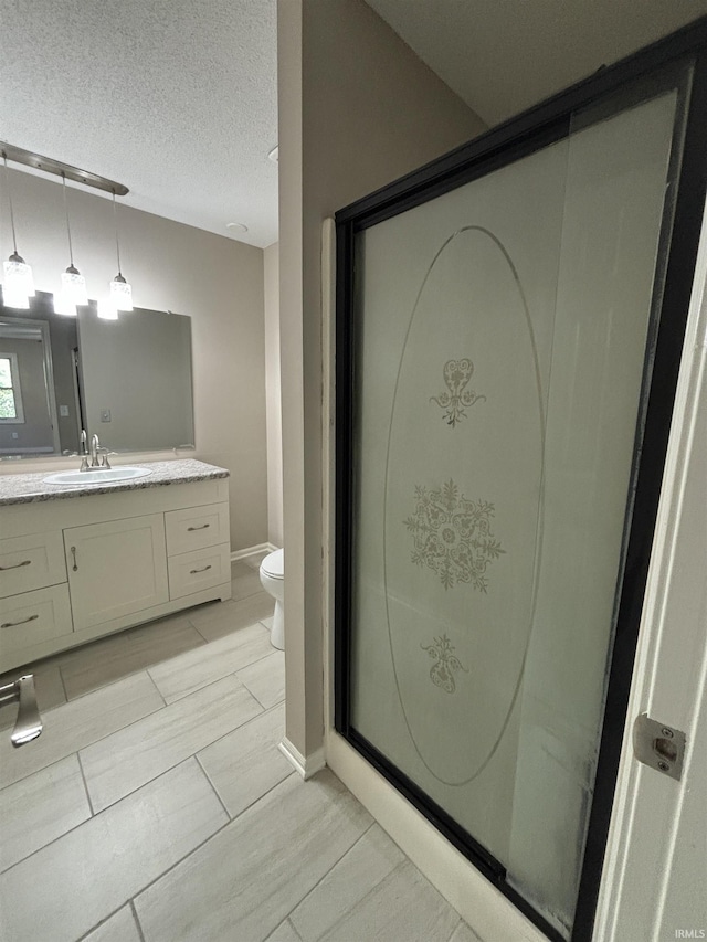 bathroom with vanity, a textured ceiling, and toilet