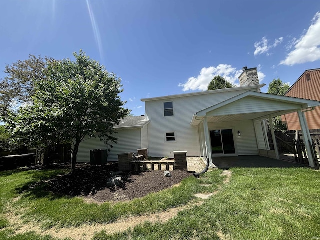 rear view of property featuring a patio and a yard