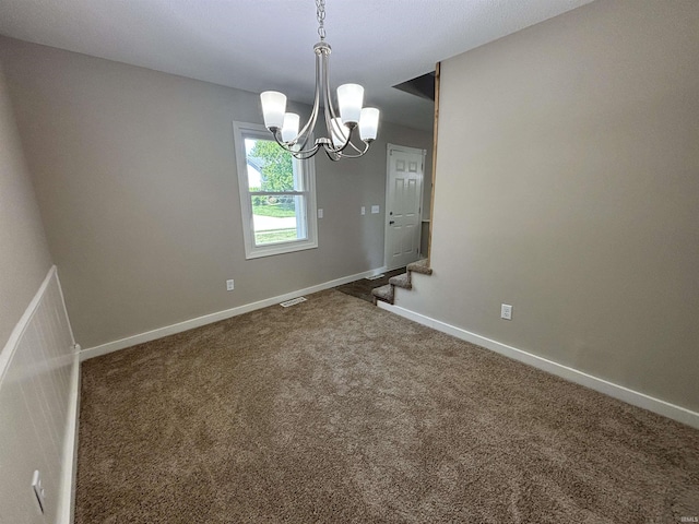 unfurnished room with carpet flooring and a notable chandelier