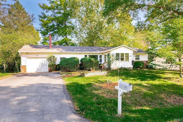 single story home with a garage and a front lawn