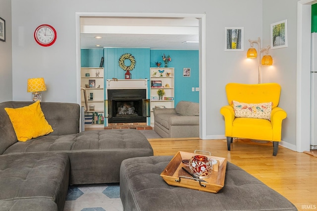 living room with hardwood / wood-style flooring and a brick fireplace