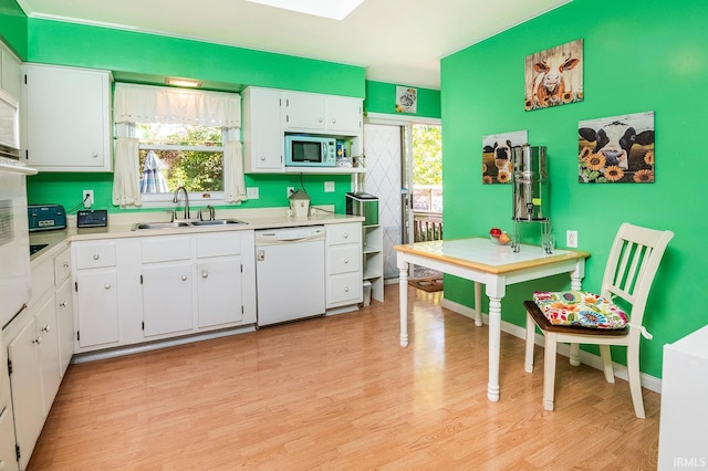 kitchen with white cabinetry, dishwasher, sink, and a healthy amount of sunlight