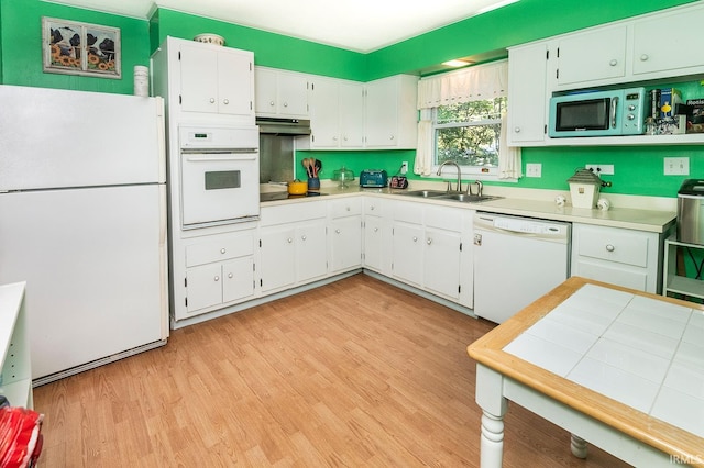 kitchen featuring white cabinetry, sink, white appliances, and light hardwood / wood-style flooring