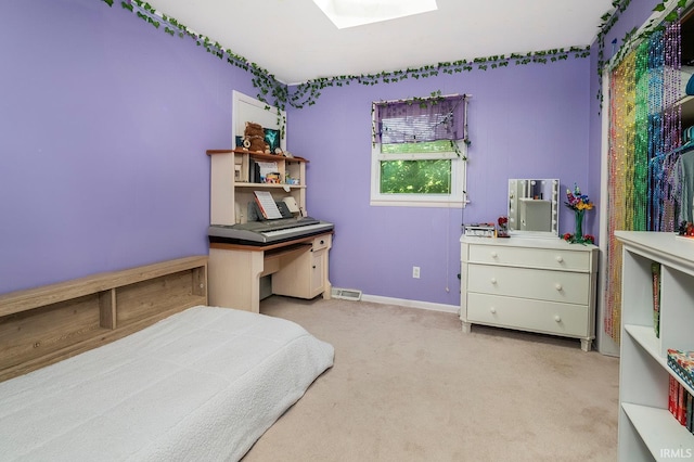 bedroom with a skylight and light carpet