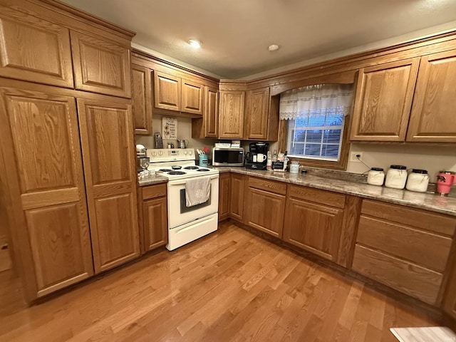 kitchen featuring white electric range and light hardwood / wood-style floors