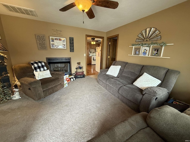 living room with ceiling fan and carpet