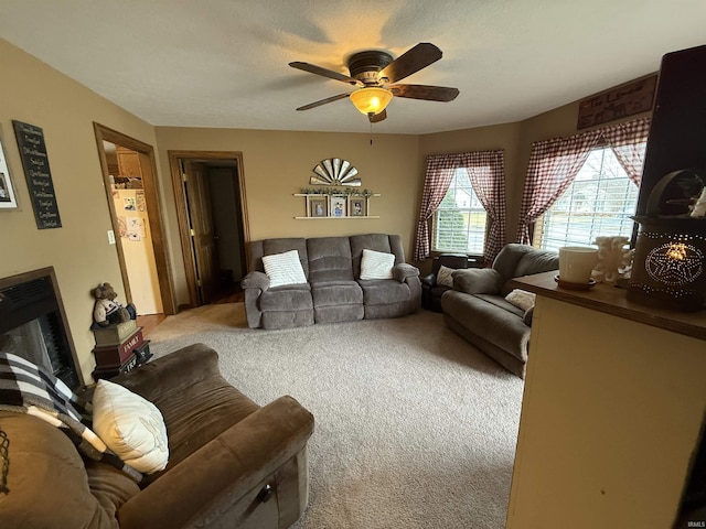 living room featuring ceiling fan, light carpet, and a textured ceiling