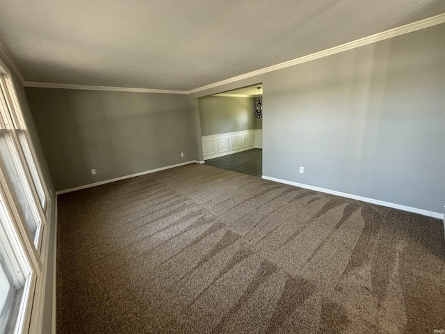 carpeted spare room featuring crown molding