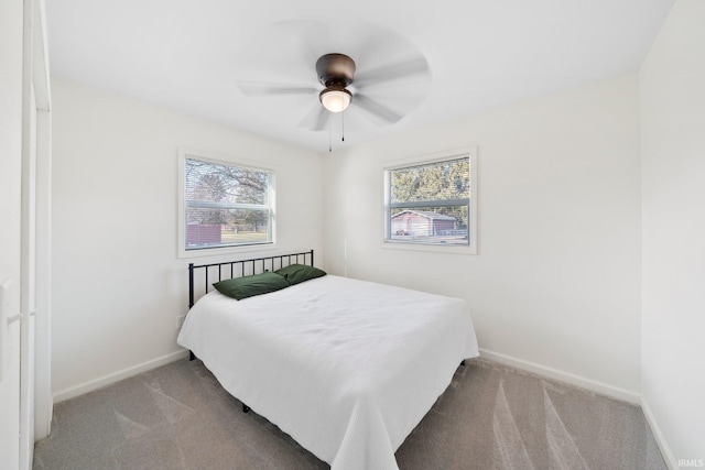 bedroom featuring multiple windows, light carpet, and ceiling fan