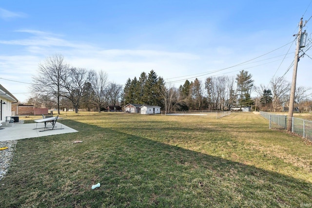 view of yard featuring a storage unit and a patio