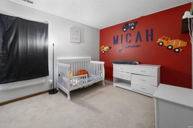 carpeted bedroom with a nursery area