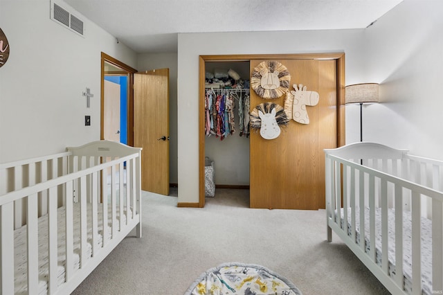 bedroom with light colored carpet, a textured ceiling, and a closet