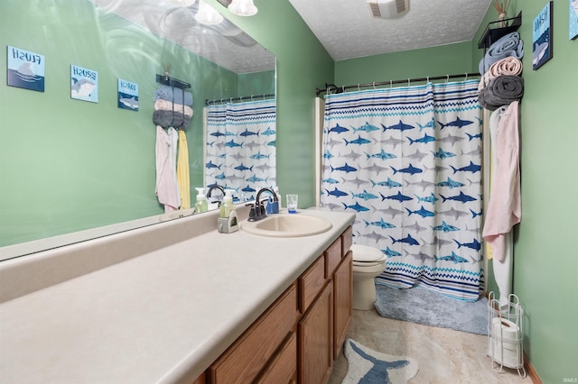 bathroom featuring a shower with curtain, vanity, toilet, and a textured ceiling