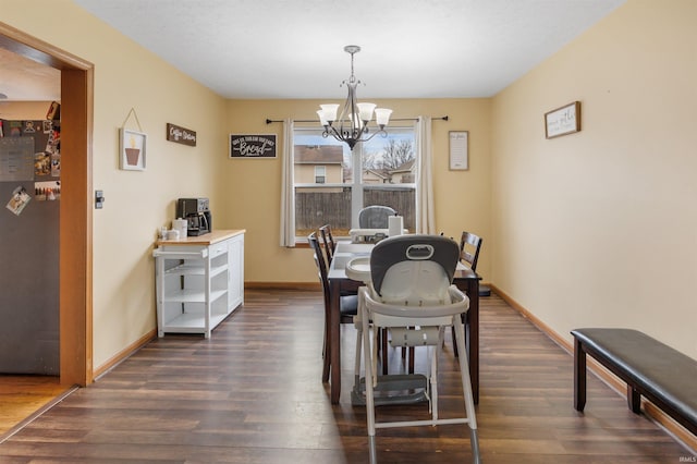 dining area featuring dark wood-type flooring and a chandelier