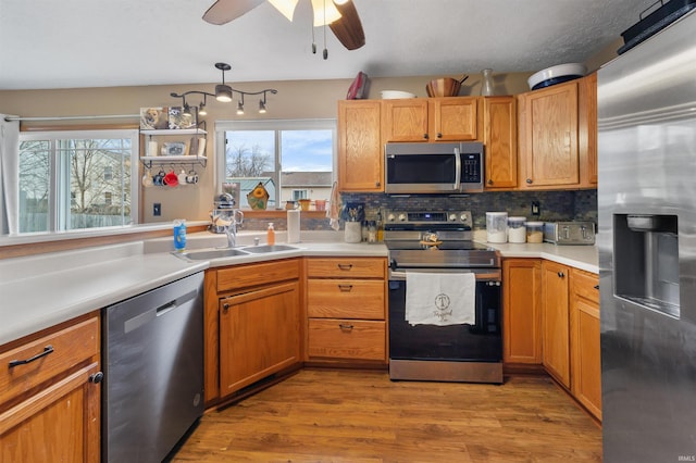 kitchen featuring a healthy amount of sunlight, stainless steel appliances, sink, and hanging light fixtures