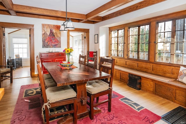 dining space featuring beamed ceiling and light wood-type flooring