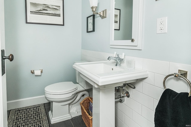 bathroom featuring tile walls, tile patterned floors, and toilet