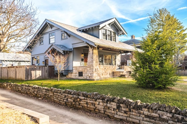 craftsman inspired home with a front yard and covered porch