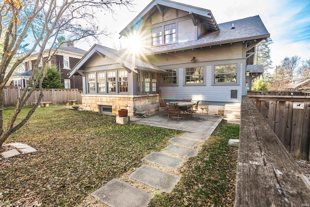 back of property with a yard and a patio area