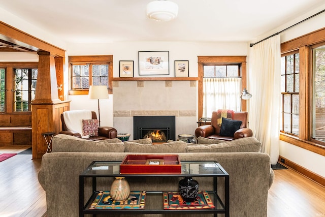 living room with a fireplace, hardwood / wood-style floors, and decorative columns