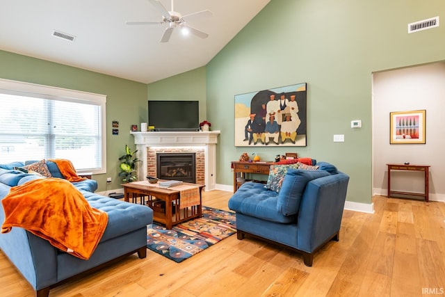 living room with ceiling fan, high vaulted ceiling, and light hardwood / wood-style flooring