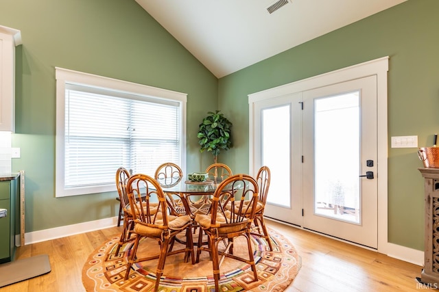 dining area featuring vaulted ceiling, light hardwood / wood-style flooring, and a wealth of natural light