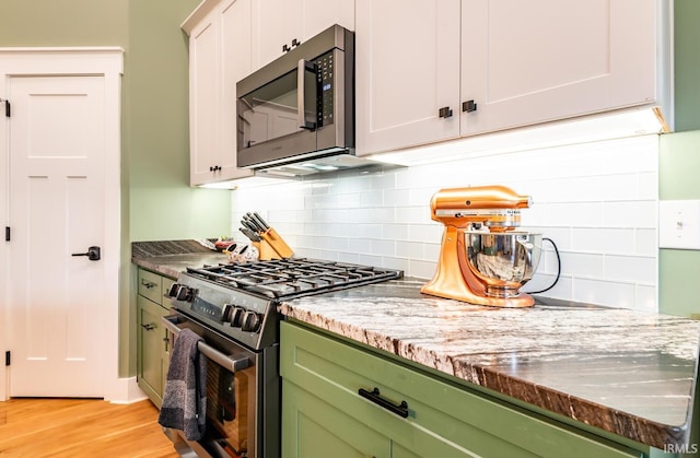 kitchen featuring light hardwood / wood-style flooring, stainless steel appliances, tasteful backsplash, white cabinets, and stone countertops