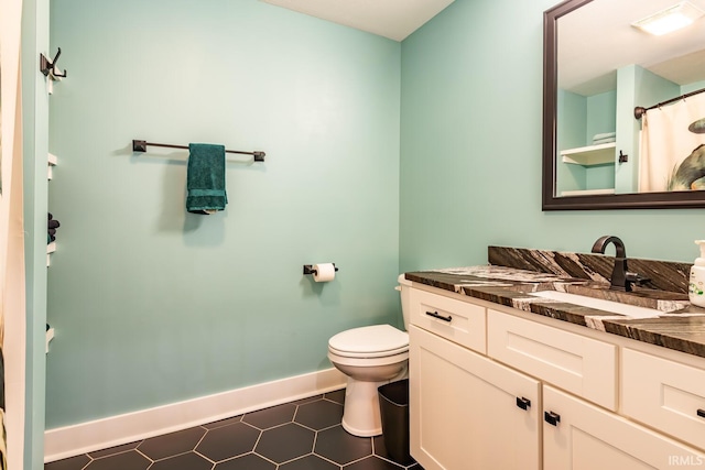 bathroom with tile patterned flooring, vanity, and toilet