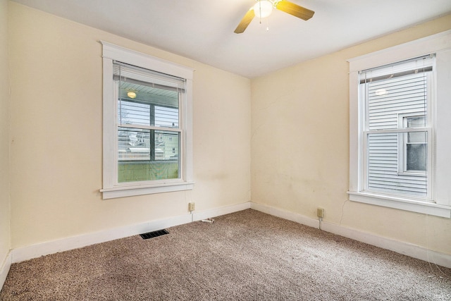 carpeted spare room featuring ceiling fan