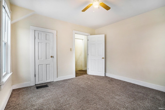 unfurnished bedroom with ceiling fan, carpet flooring, and vaulted ceiling