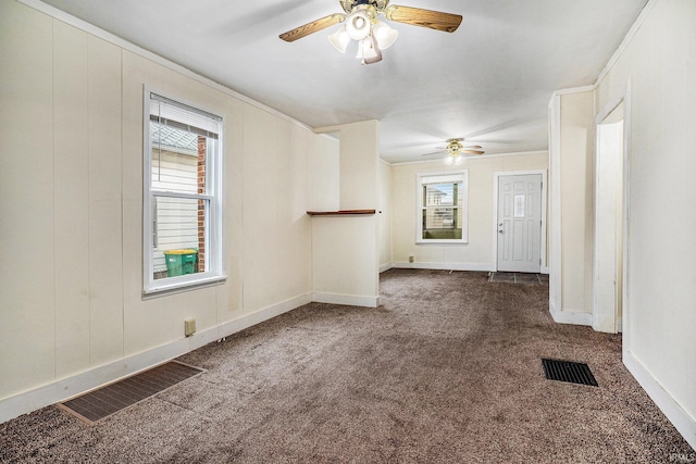 unfurnished living room featuring ceiling fan and dark colored carpet