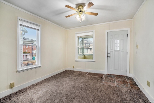 carpeted entryway with ceiling fan and ornamental molding