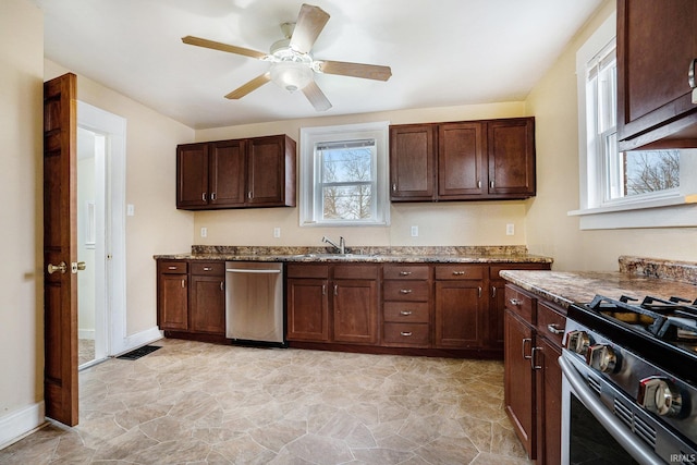 kitchen featuring sink, dark brown cabinets, stone counters, ceiling fan, and stainless steel appliances