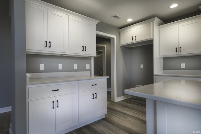 kitchen with dark wood-type flooring and white cabinets