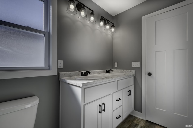 bathroom featuring vanity, wood-type flooring, and toilet