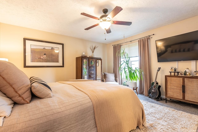 bedroom with ceiling fan, carpet, and a textured ceiling