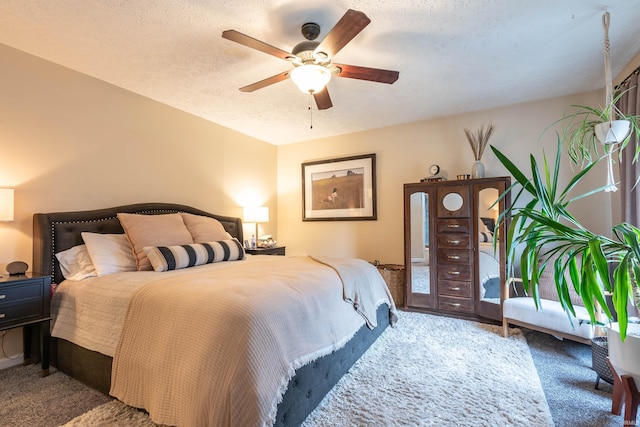 carpeted bedroom with ceiling fan and a textured ceiling