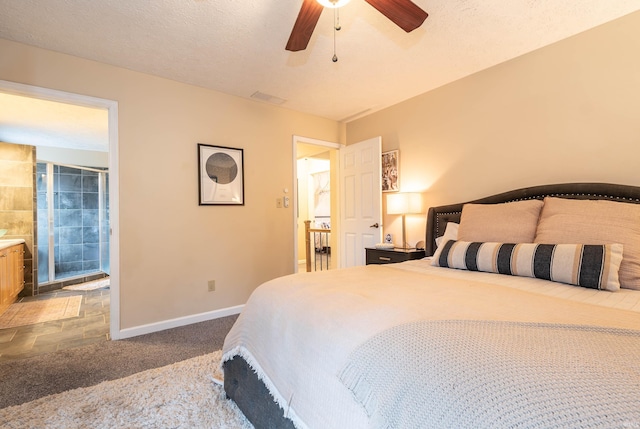 bedroom featuring ceiling fan, connected bathroom, carpet floors, and a textured ceiling